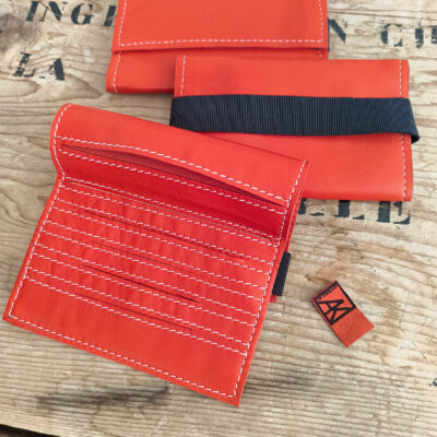 blagues à tabac en agneau plongé rouge vermillon dont le moyen de fermeture est un élastique noir large de 2,5 cm